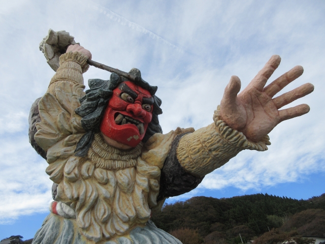 左手を伸ばし、大迫力の赤鬼=なまはげのモニュメント