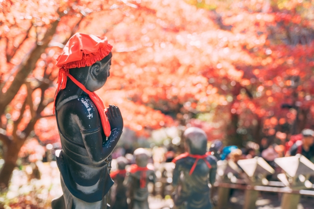 紅葉の下、大山寺のお地蔵さんが手を合わせて立っている