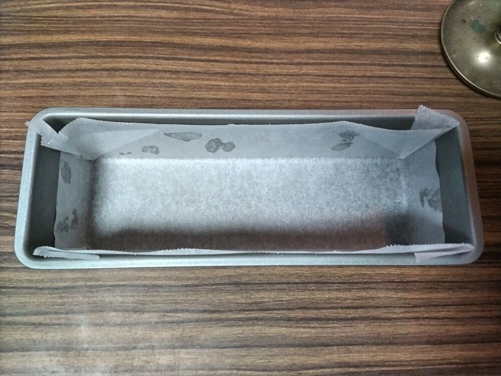 オーブンシートをきちっちりと敷かれたパウンドケーキ型
