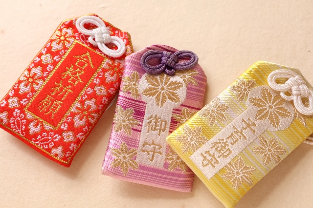 日本のお守り三つ。赤、桃、黄色でかわいい。