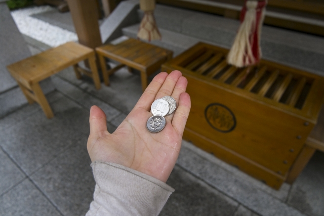 お賽銭用に掌に置かれた三百円