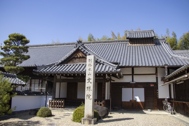 晴天の下の文殊院の建もの。文殊院の文字が見える。
