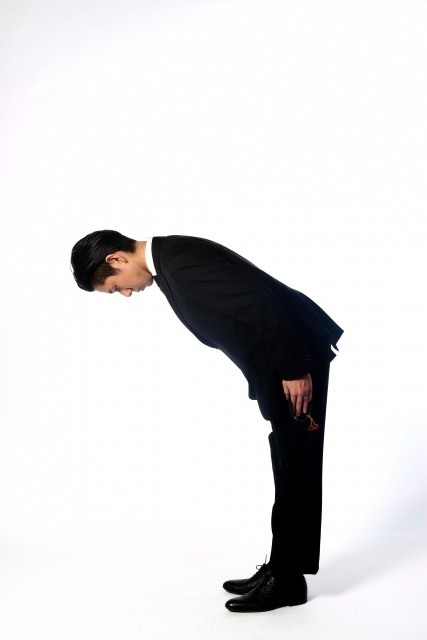 90度の深い礼をする男性