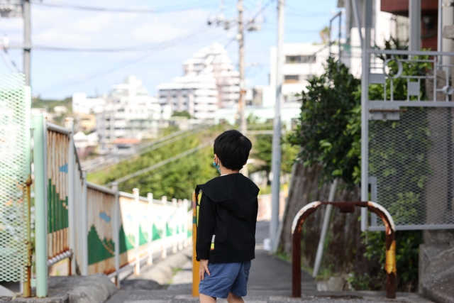 町中に一人でいる男の子の後ろ姿