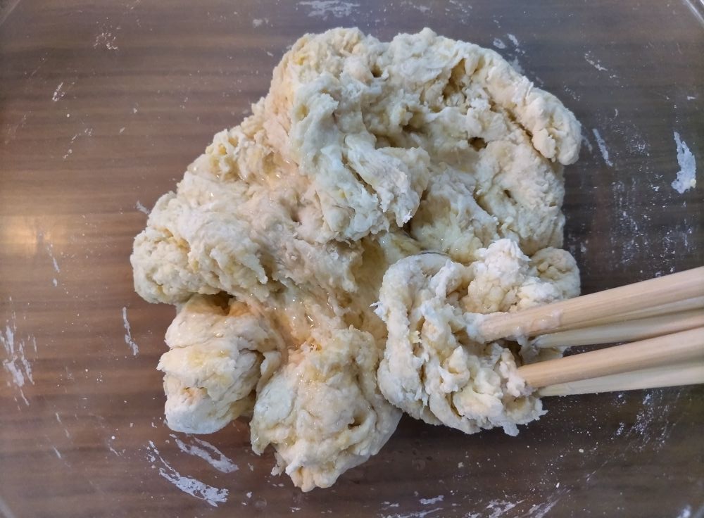 数本の箸で生地を混ぜている