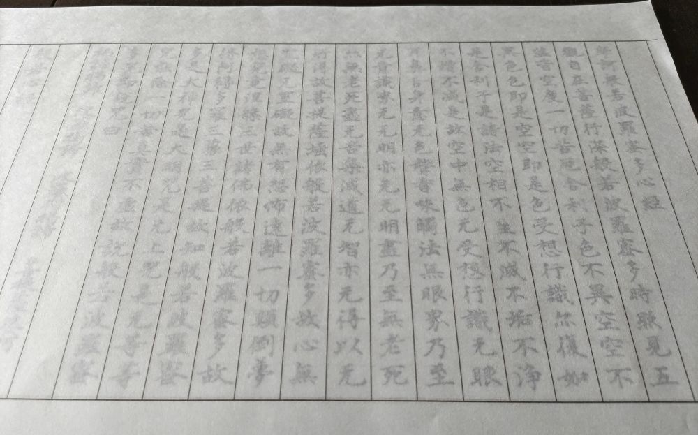 下にお経のお手本を置いて、上に半紙を重ねた状態。字は薄く、良く見えない。